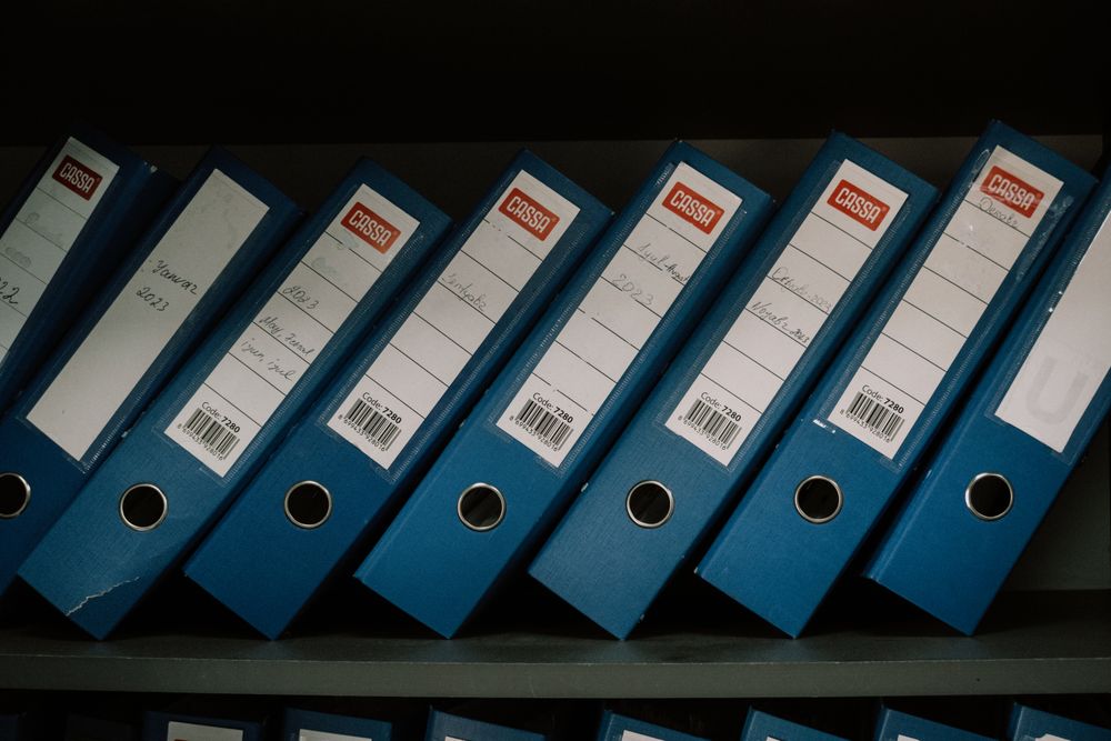 A row of matching blue folders on a shelf