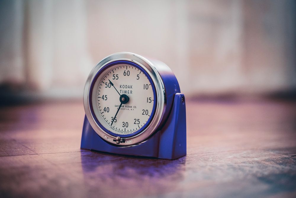 A vintage kitchen timer on a wooden table