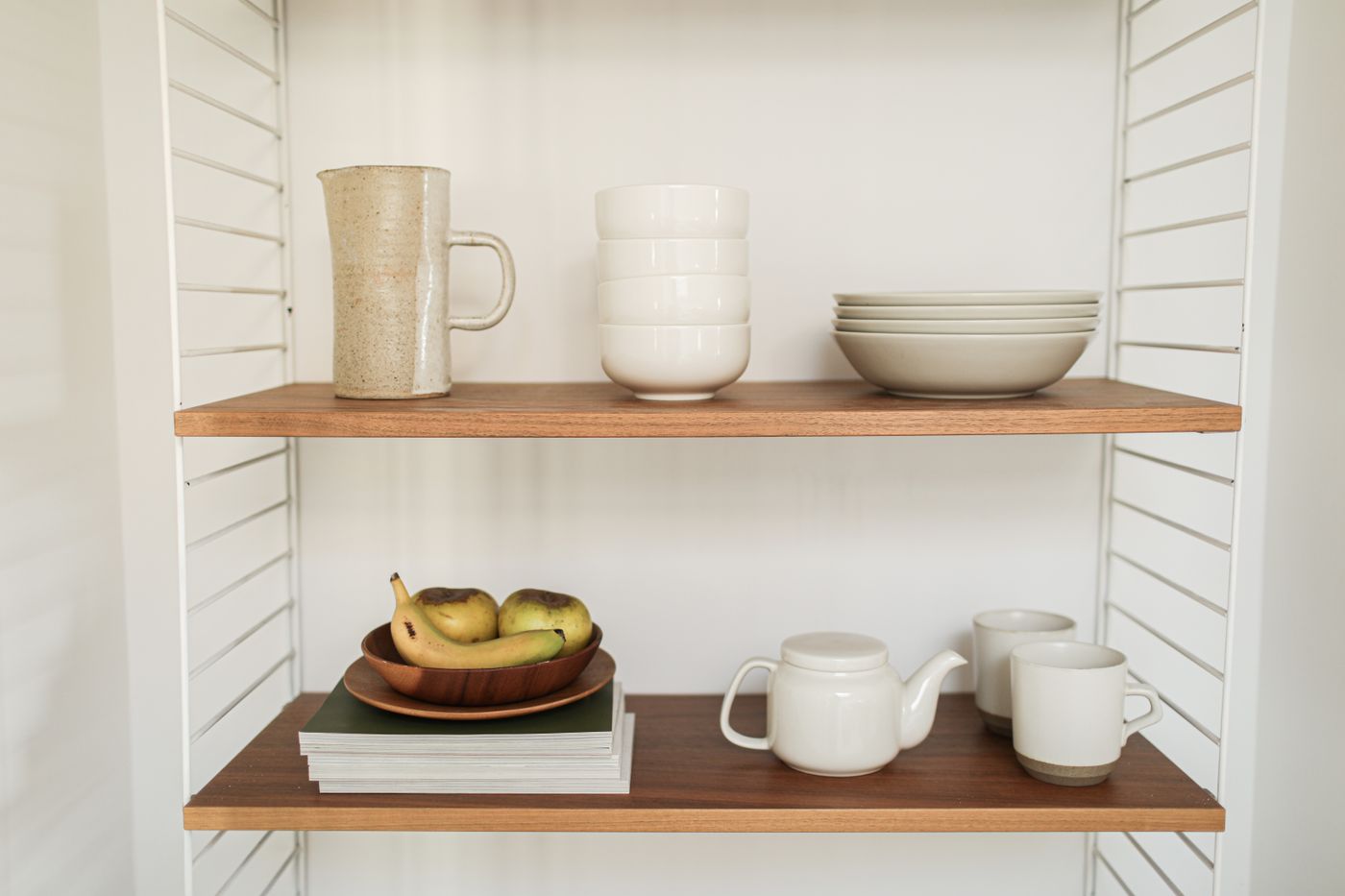 A few pieces of cream ceramics neatly arranged on wall shelves
