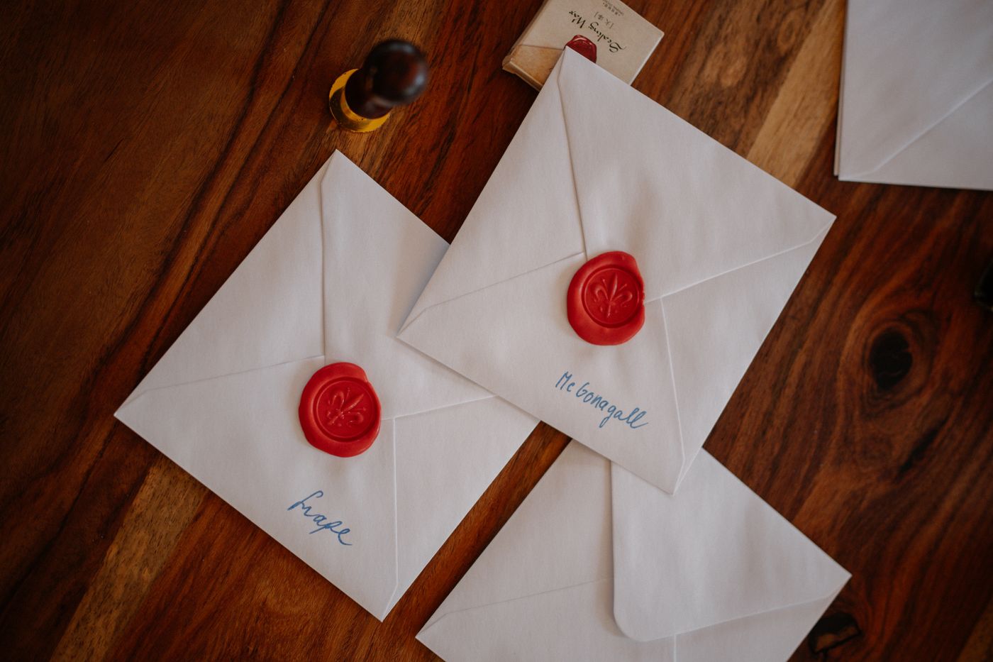 Two envelopes closed with red wax seals on a wooden desk