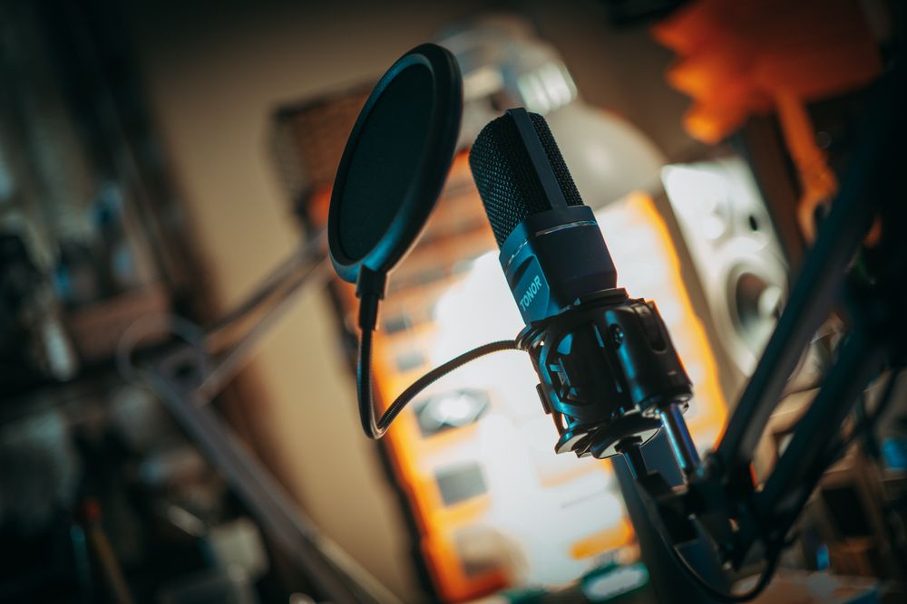 A studio microphone with a pop filter in warm light